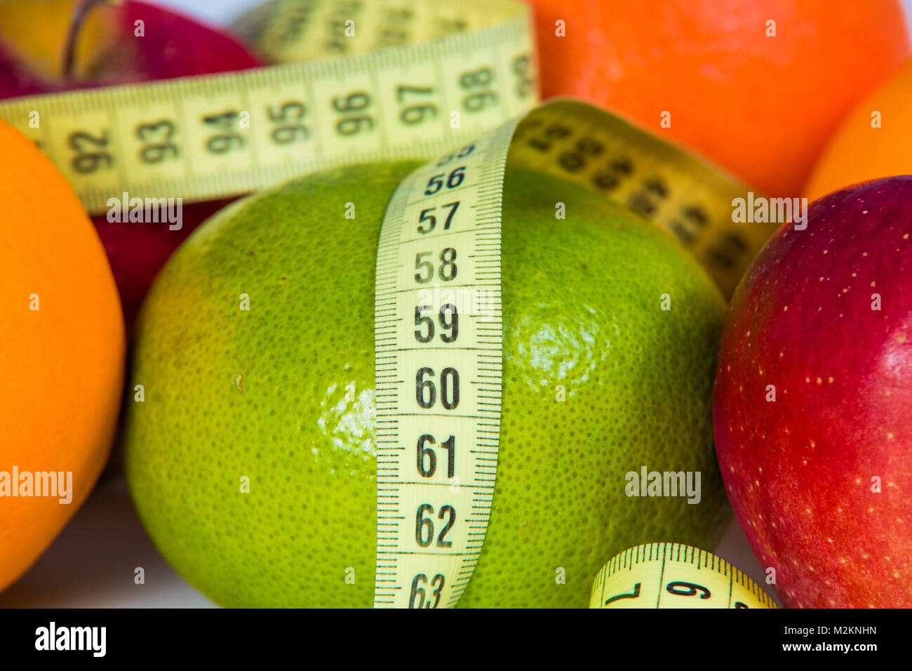 Measuring tape on green grapefruit close-up. Diet background. Stock Photo