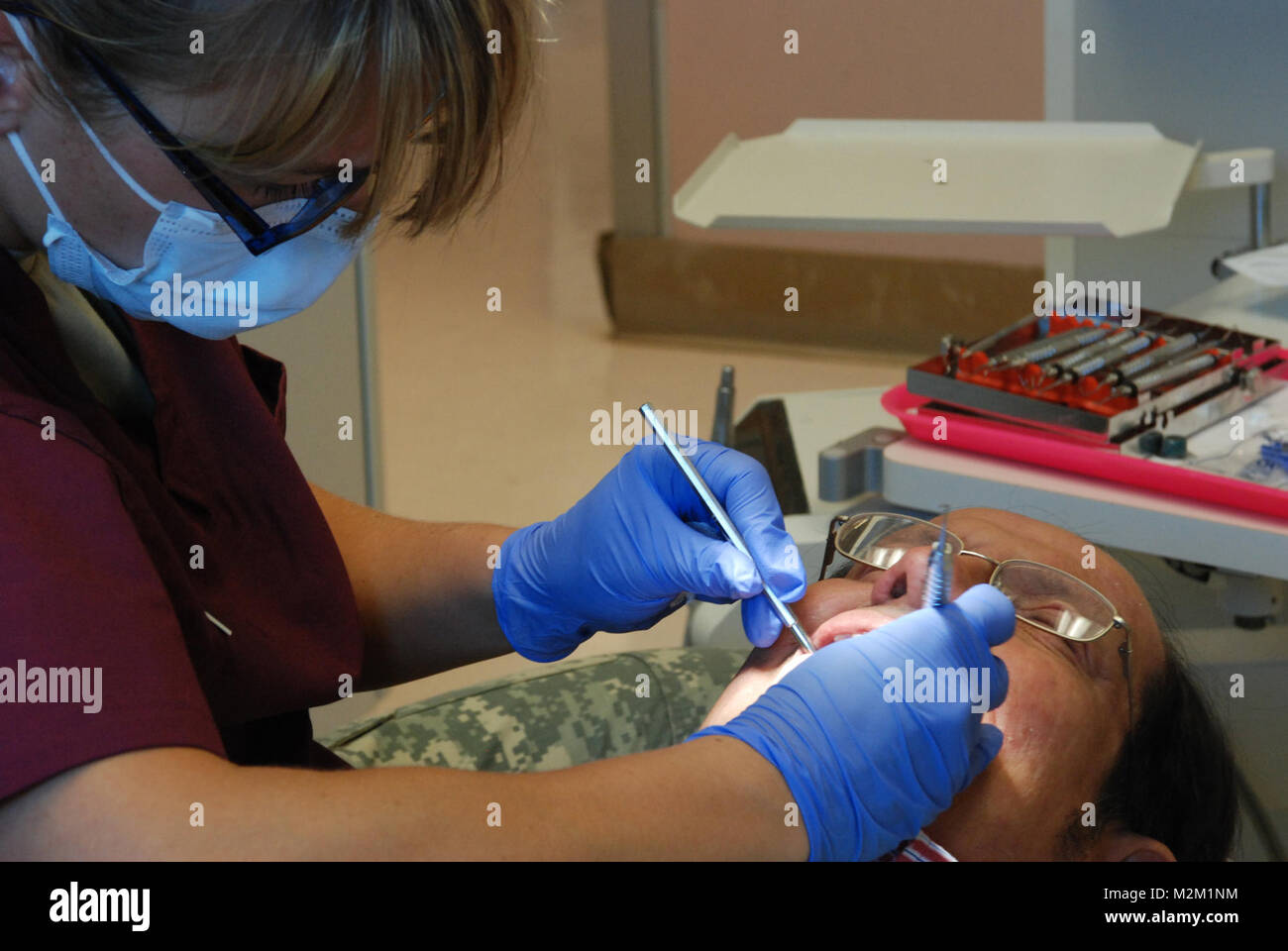 Staff Sgt. Amber McGraw, dental hygienist, 455th Medical Company (Dental Services) out of Devens, Mass., performs a routine dental cleaning for Ernie Liitle, a local resident, at the Pine Ridge Reservation Hospital on June 12. (U.S. Army Photo by 1st Lt. Yliana M. Raphael) Routine dental cleaning by MilitaryHealth Stock Photo