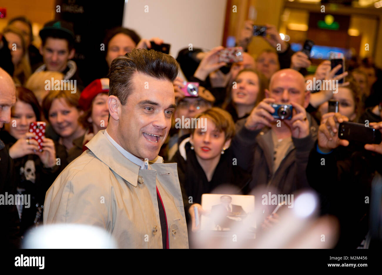 Robbie Williams kommt durch ein Spalier von Fans zur Präsentation seines Männermode-Labels 'Farrell' ins KaDeWe Berlin, am 26.02.2013 Stock Photo