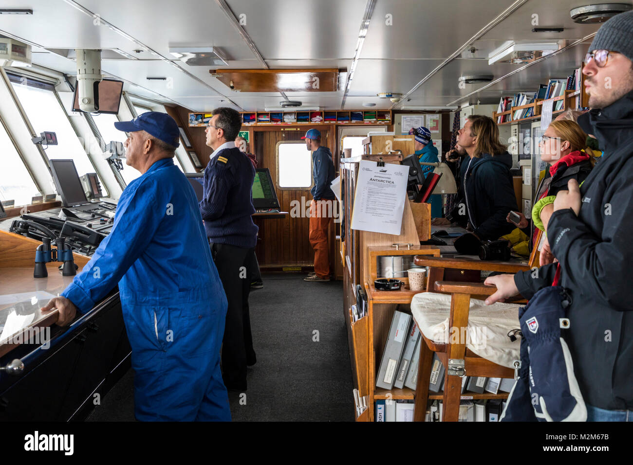 Ship's crew on bridge sailing passenger ship Ocean Adventurer; carries alpine mountaineering skiers to Antarctica Stock Photo