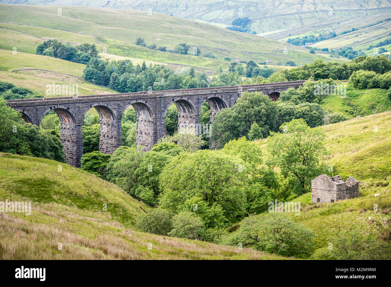 Extensive stone bridge allows for trains to cross over rolling hills of the Dales, Yorkshire Dales, UK Stock Photo