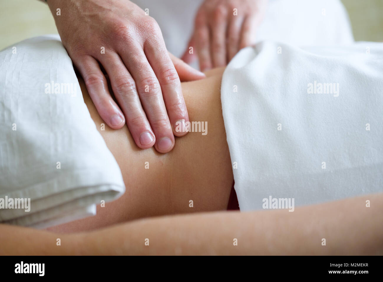 Close up of female belly getting massage by  professional masseur. Body care, skin care, wellness, wellbeing, health, beauty treatment concept. Stock Photo
