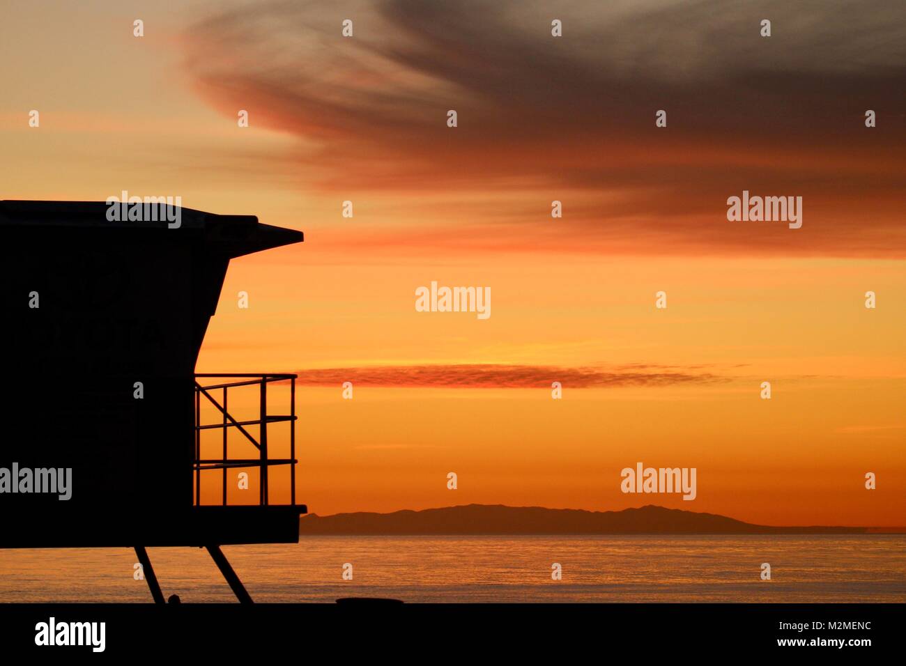 Beautiful ocean sunset with Lifeguard tower silhouette Stock Photo