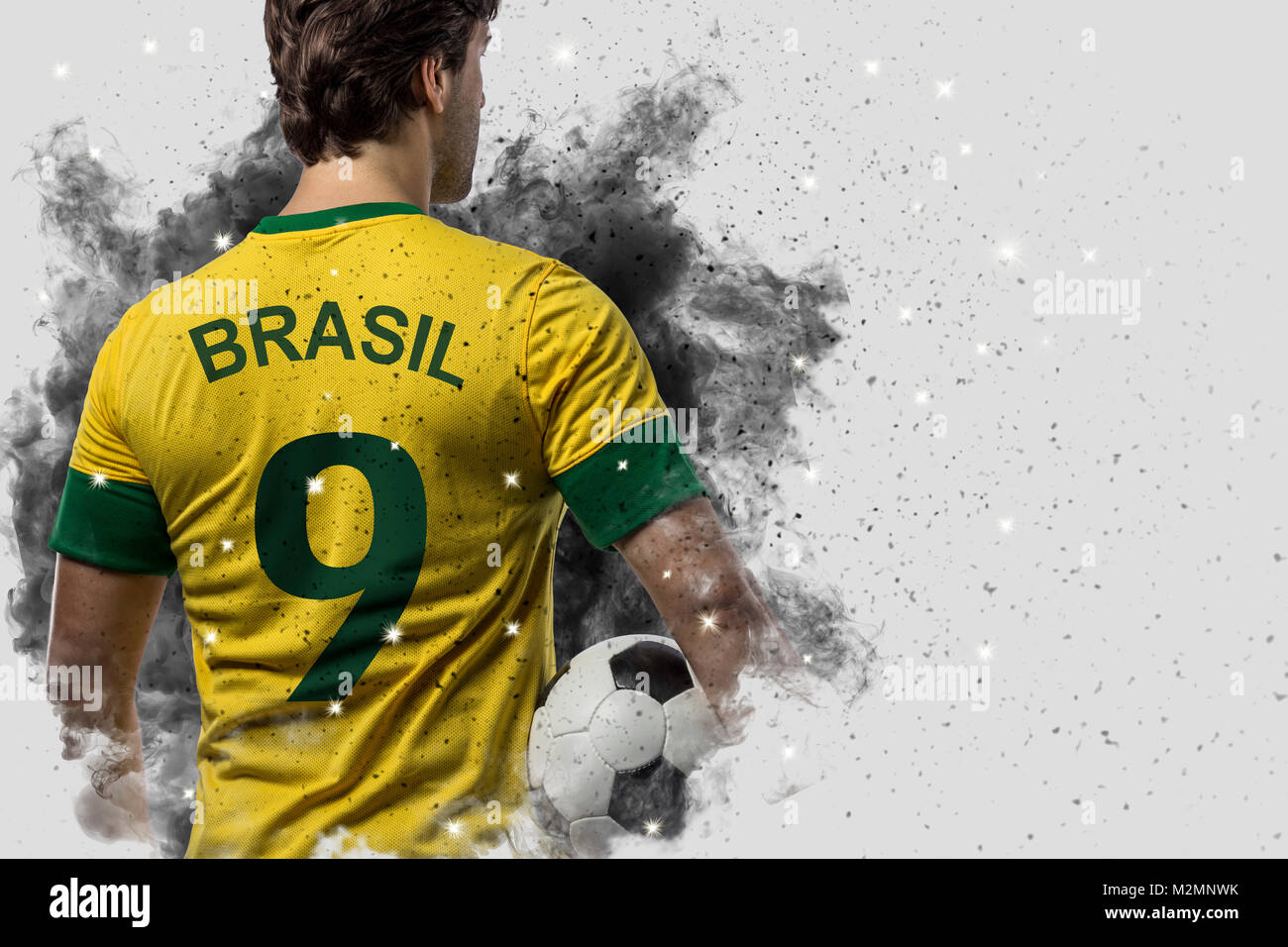 Brazilian soccer player coming out of a blast of smoke. celebrating. Stock Photo