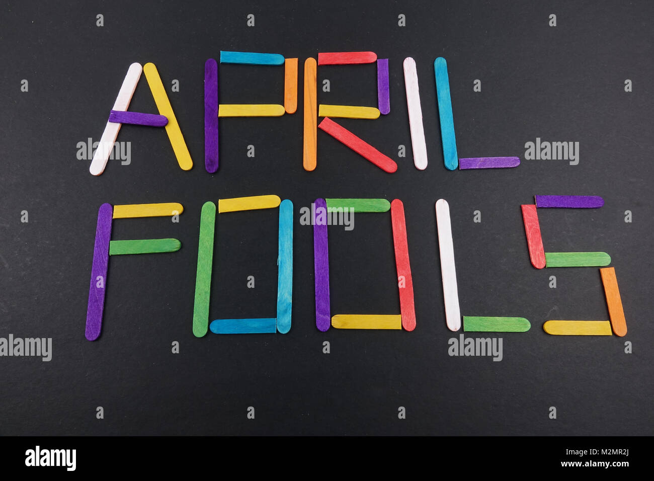 April Fools background with colourful sticks on black background Stock