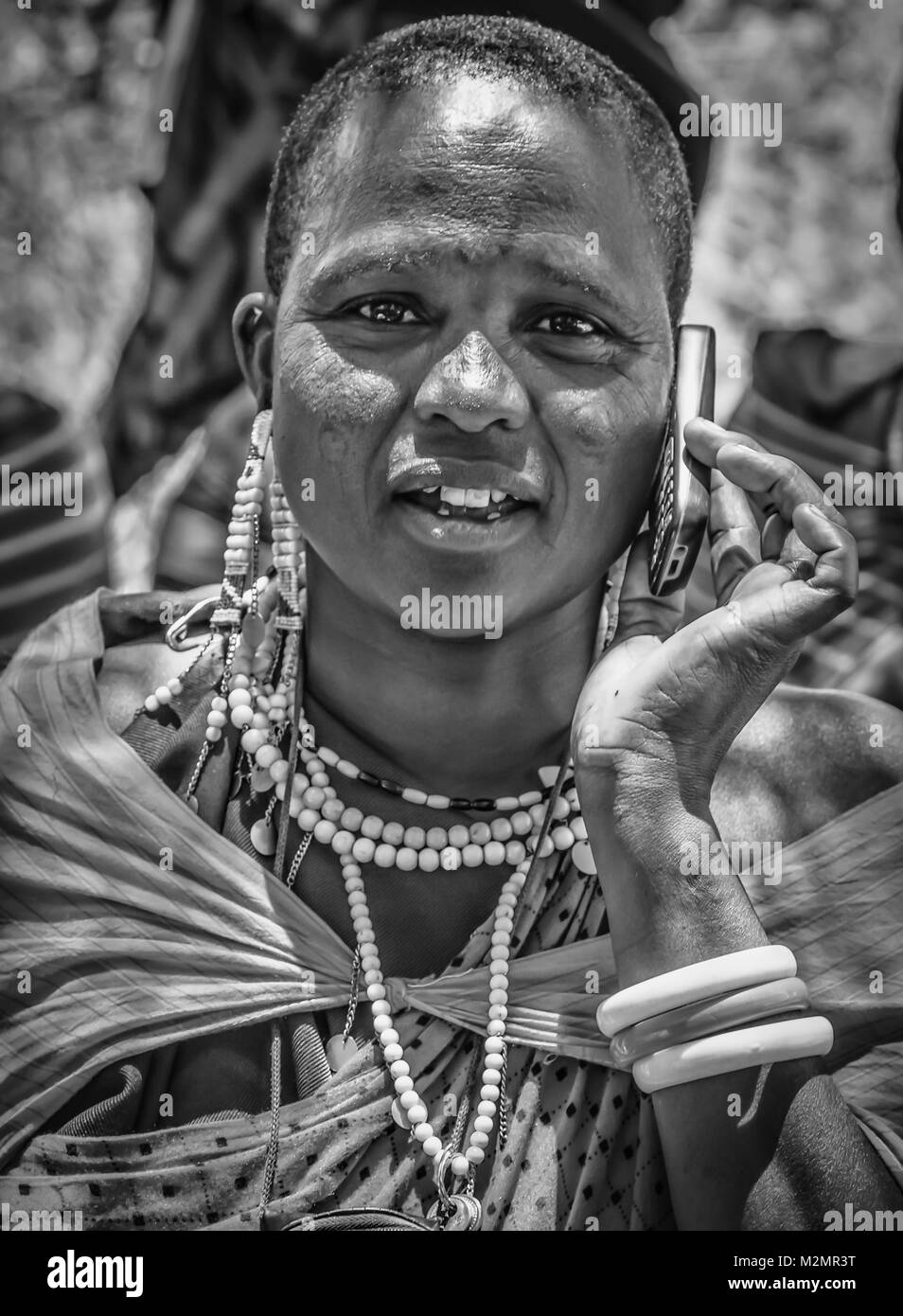 Maasai woman on cell phone in black & white in Tanzania, Africa in the Kilimanjaro region Stock Photo