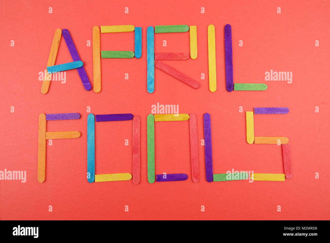 April Fools background with colourful sticks on red background Stock