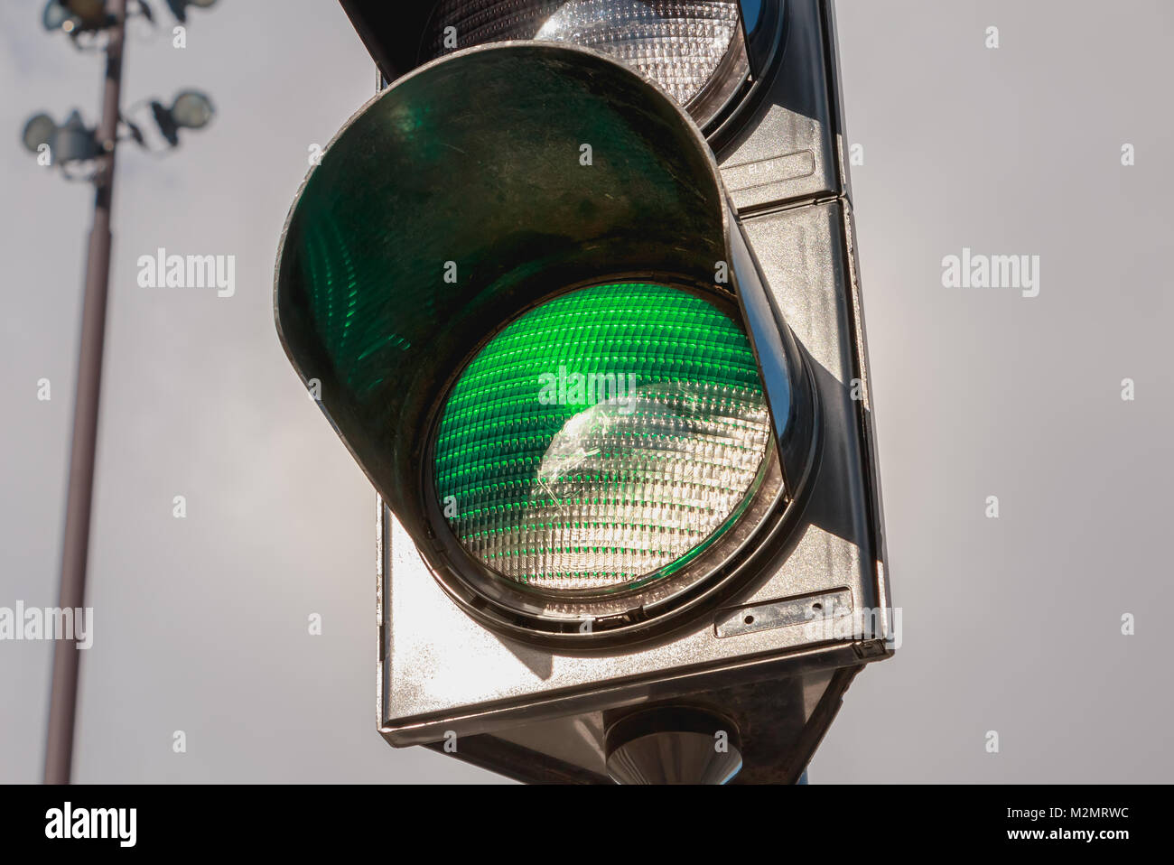 closeup of a green traffic light on gray sky background Stock Photo - Alamy