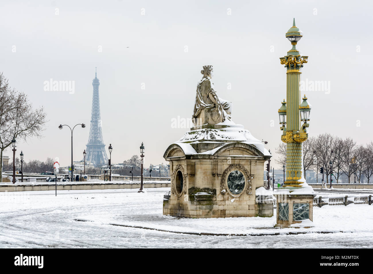 Winter in Paris in the snow. The Concorde square covered in snow with the statue of Marseille in the foreground and the Eiffel tower in the distance. Stock Photo