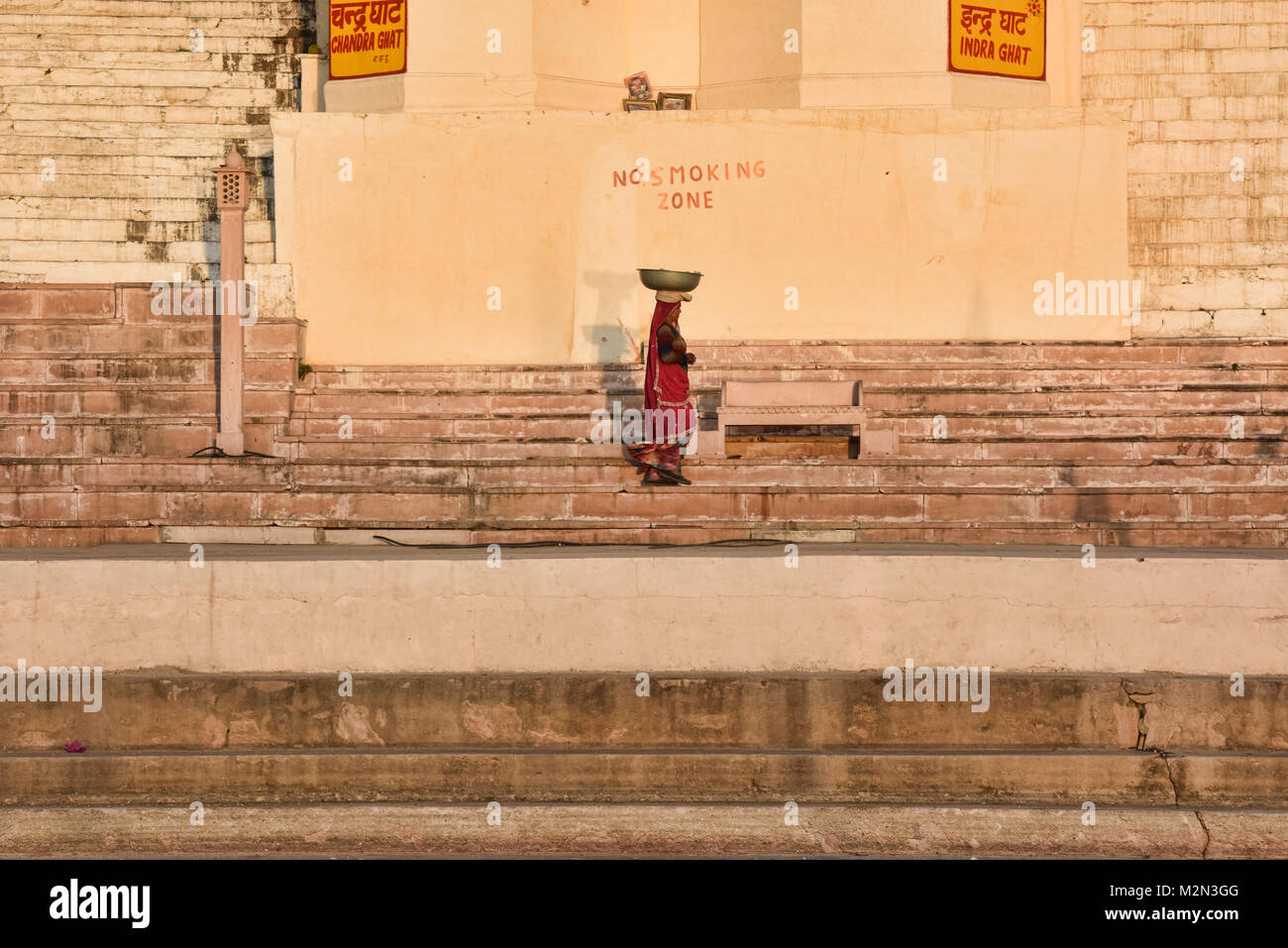 Lone woman on the bathing ghat in the holy town of Pushkar, Rajasthan, India Stock Photo