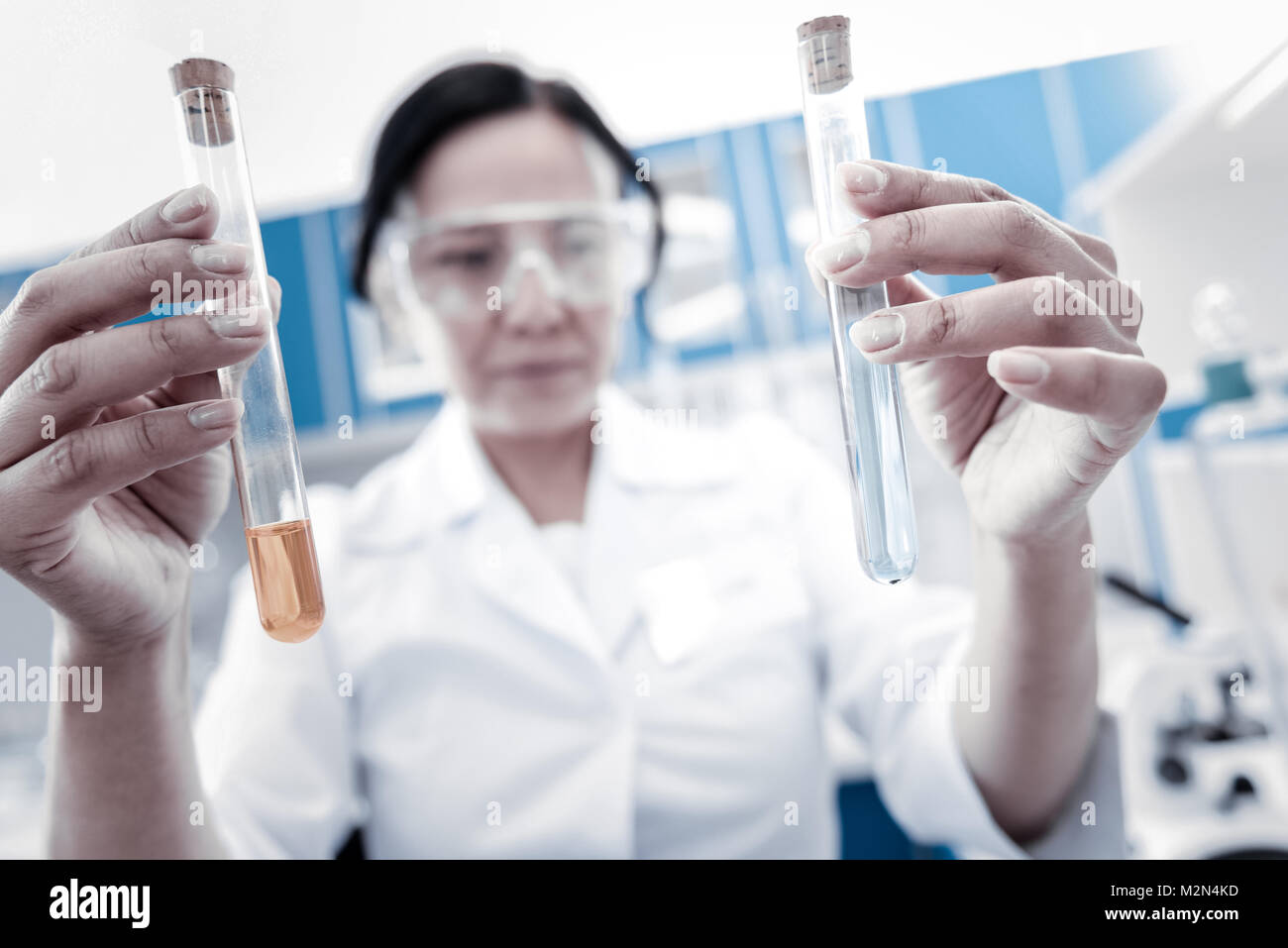 Female professional comparing chemical liquids in test tubes Stock Photo