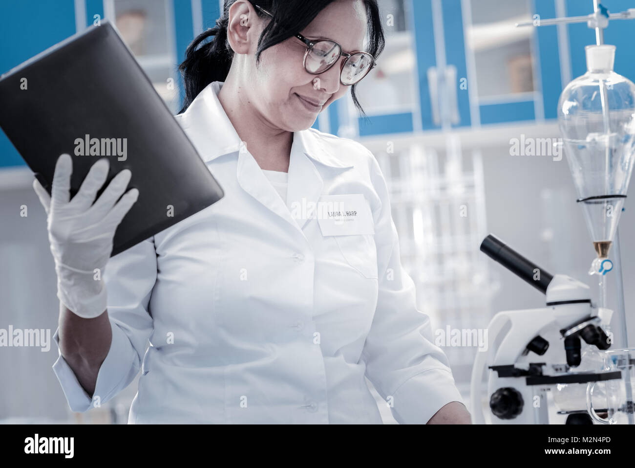 Positive minded scientist using touchpad while working in lab Stock Photo