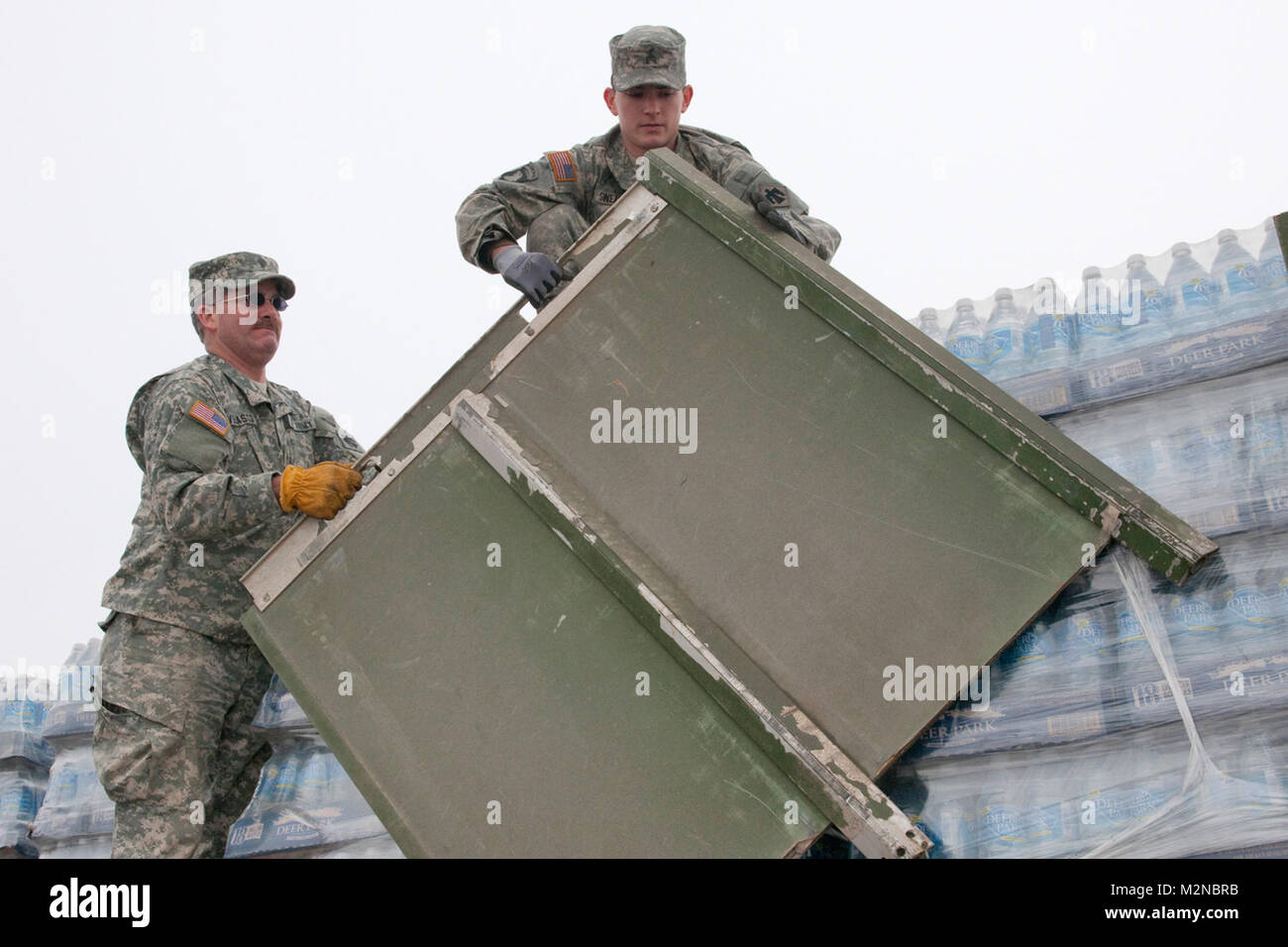 Members of the Oklahoma Army National Guard were called to state active duty in support of Operation Frosty, a relief effort for areas hit hardest by an ice storm on Jan 28 and 29, 2010. Spc. Michael Velasco of Midwest City & Deming, N.M (left) and Sgt. Cody Swearingen of Midwest City remove side panels from their vehicle in order to off-load pallets of water at the Anadarko Fire Department. Anadarko Resupply by Oklahoma National Guard Stock Photo