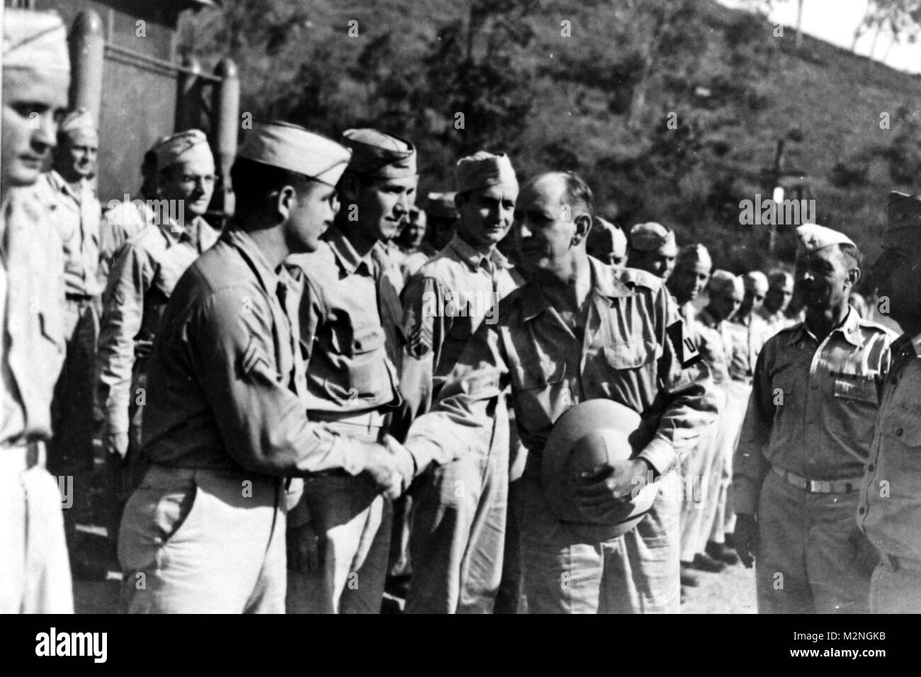 PORT MORESBY, New Guinea, September 10, 1943 – Senator Richard Russell of Georgia shakes hand with Cpl. Ellis Page of the 101st AAA Separate Battalion during his tour of inspection. To the right is Major S. W. Griffin, commander of the 101st AAA, and a future Adjutant General and Governor of Georgia. Photo 231963, National Archives Records Administration (NARA), College Park, Md. Future TAG in Papau by Georgia National Guard Stock Photo