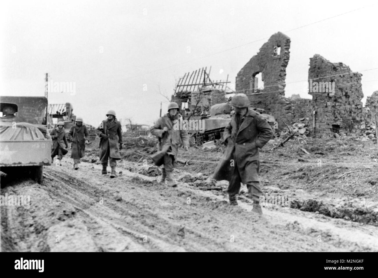 HURTGEN, Germany, December 5, 1944 Soldiers of the Company I, 3rd Battalion, 121st Infantry Regiment move down the main road amid the ruins of Hurtgen, Germany. Photo 270805, National Archives Records Administration (NARA), College Park, Md. Ruins of Hurtgen by Georgia National Guard Stock Photo