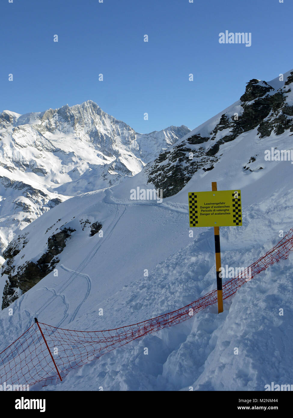 Winter scenes in the snowsports resort of Zinal in Valais canton of Switzerland and showing the avalanche warning sign at start of the free ride area. Stock Photo