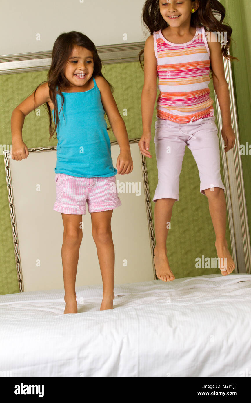 Kids laughing jumping on the bed. Stock Photo