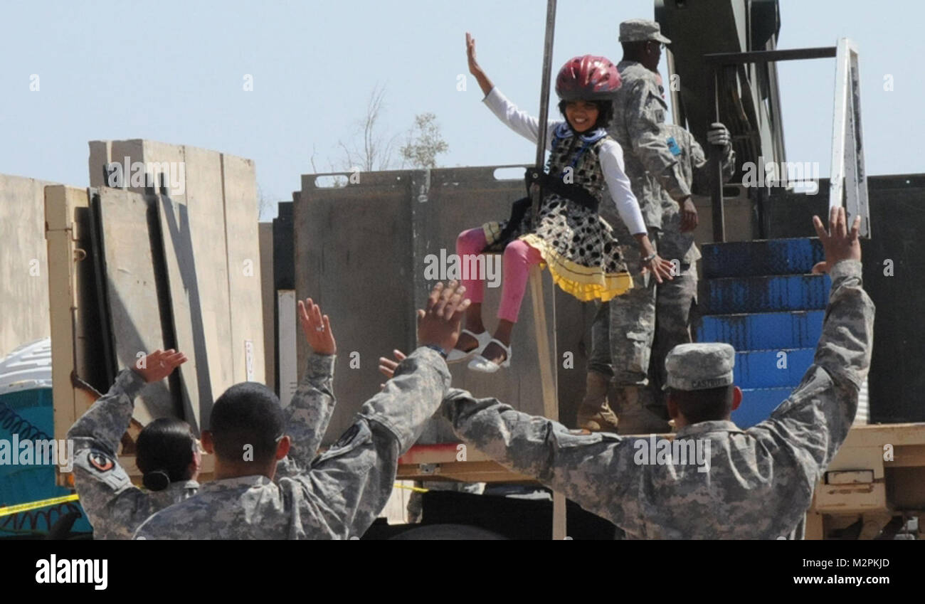 Going down the zip line. JOINT BASE BALAD, Iraq – A local Iraqi girl soars down the zip line into the awaiting arms of U.S. Army Soldiers during an Iraqi Kids Day, March 26, 2011, at Joint Base Balad, Iraq. Soldiers of 2nd Brigade, 25th Infantry Division, joined units at Joint Base Balad, hosting approximately 100 Iraqi children participated in the day’s events, to include rappel rides, face painting, sport activities, and a piñata filled with candy and toys.  (U.S. Army photo by Staff Sgt. Ricardo Branch, 2nd AAB PAO, 25th Inf. Div., USD-N) Going down the zip line by United States Forces - Ir Stock Photo