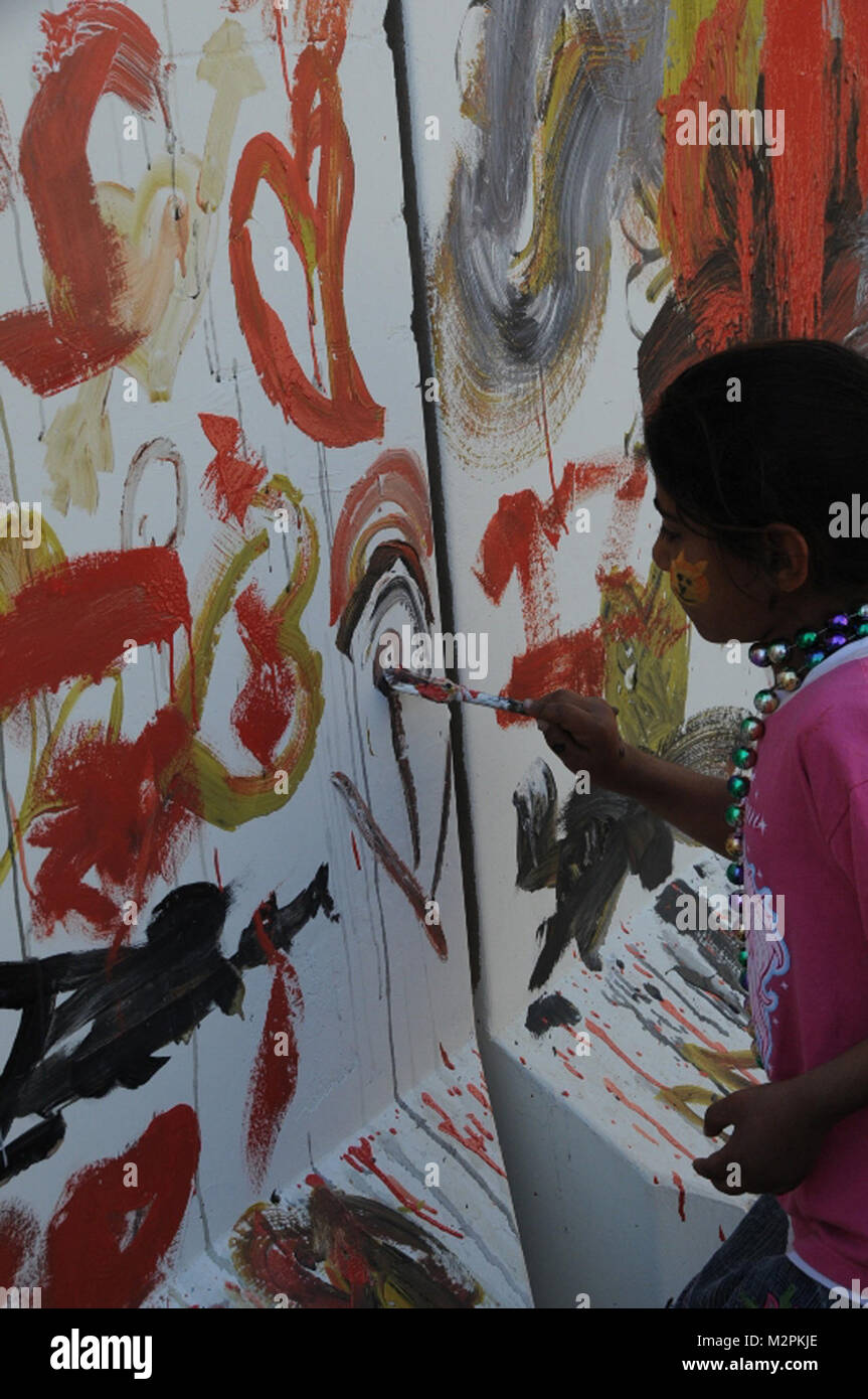 Painting fun. JOINT BASE BALAD, Iraq – A local Iraqi girl paints on one of the many T-walls at Joint Base Balad during Iraqi Kids Day, March 26, 2011. Units operating from Joint Base Balad regularly host events, such as the Iraqi Kids Day, bringing service members together with the local Iraqi community to build relationships and provide the children an opportunity to have fun. (U.S. Army photo by Staff Sgt. Ricardo Branch, 2nd AAB PAO, 25th Inf. Div., USD-N) Painting fun by United States Forces - Iraq (Inactive) Stock Photo