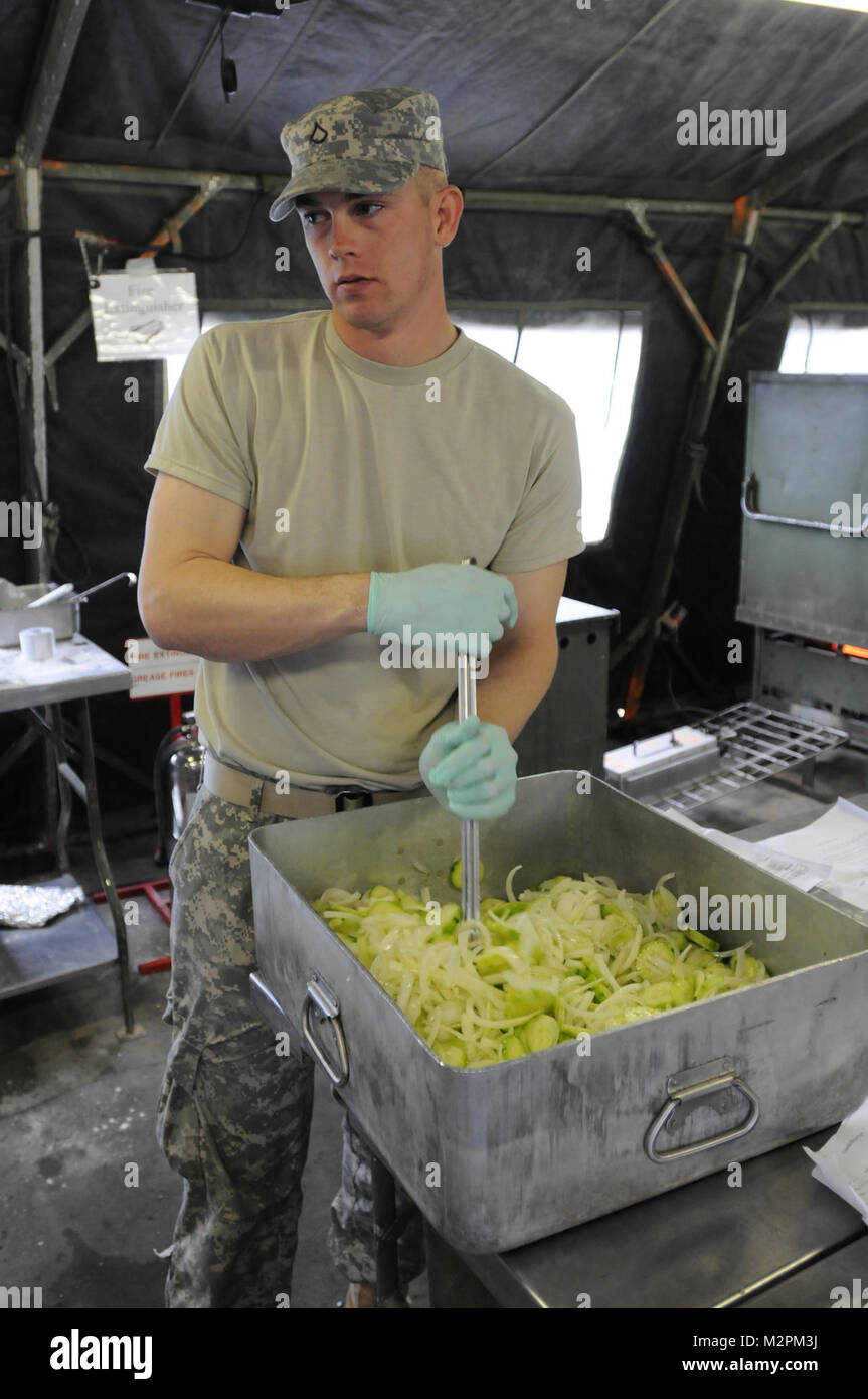 Pfc. Ian Keen from Alpha Company, 452nd Combat Support Hospital mixes cucumber salad during the U.S. Army Reserve's Connelly Competition at Fort McCoy, Wis., on April 9.  (Photo by Maj. Matt Lawrence, 807th MDSC Public Affairs) 20110409-DSC 2723 by 807MCDS Stock Photo