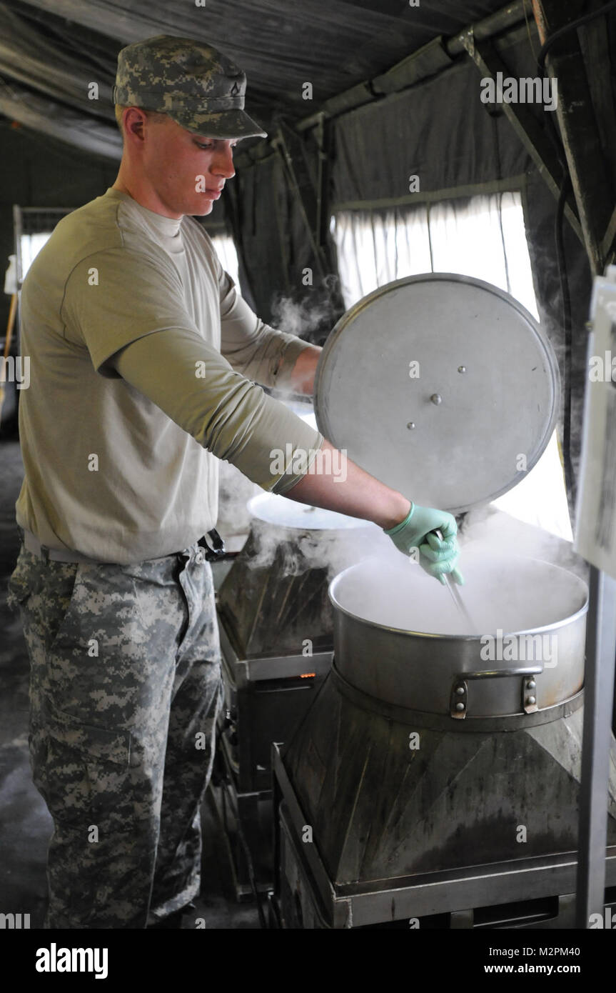 Pfc. Jacob Bruender of Alpha Company, 452nd Combat Support Hospital, stirs a pot during the U.S. Army Reserve's Connelly Competition at Fort McCoy, Wis., on April 9.  (Photo by Maj. Matt Lawrence, 807th MDSC Public Affairs) 20110409-DSC 2804 by 807MCDS Stock Photo