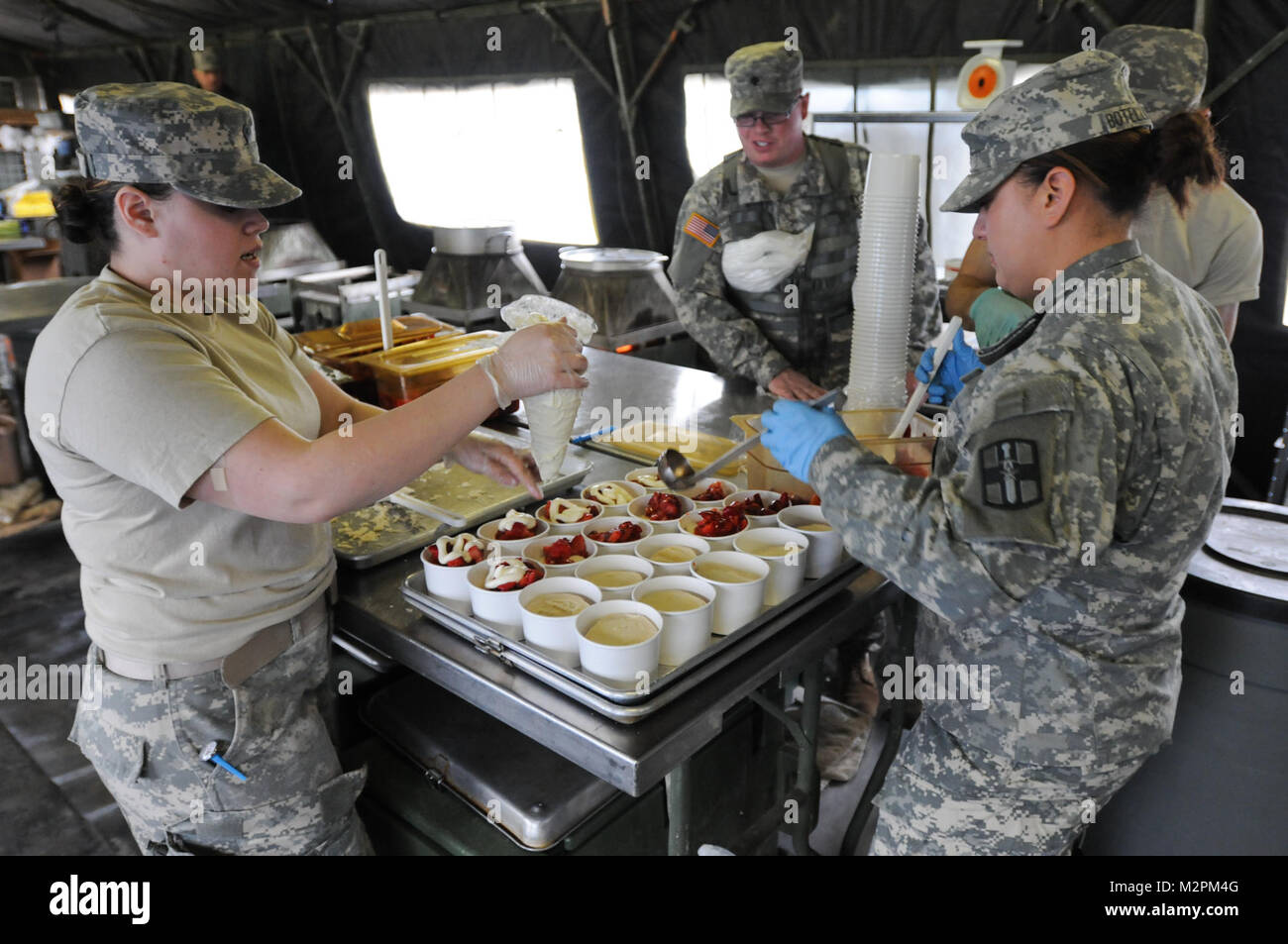 Spc. Jessica Botello-Mora and Spc. Isis Salgado of the 452nd Combat Support Hospital assemble strawberry shortcake at the U.S. Army Reserve's Connelly Competition at Fort McCoy, Wis., on April 9.  (Photo by Maj. Matt Lawrence, 807th MDSC Public Affairs). 20110409-DSC 2959 by 807MCDS Stock Photo
