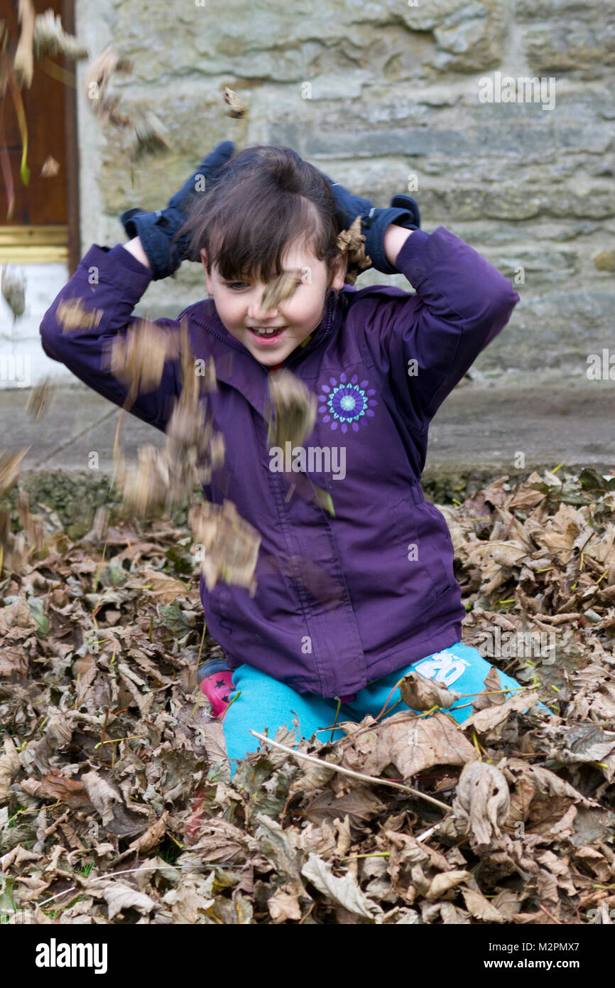Young girl playing with autumn leaves Stock Photo