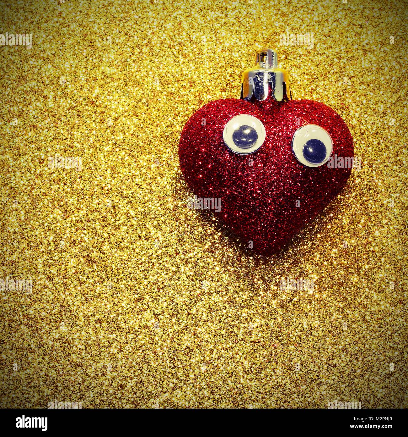 red heart with eyes on the golden background shiny with vintage effect