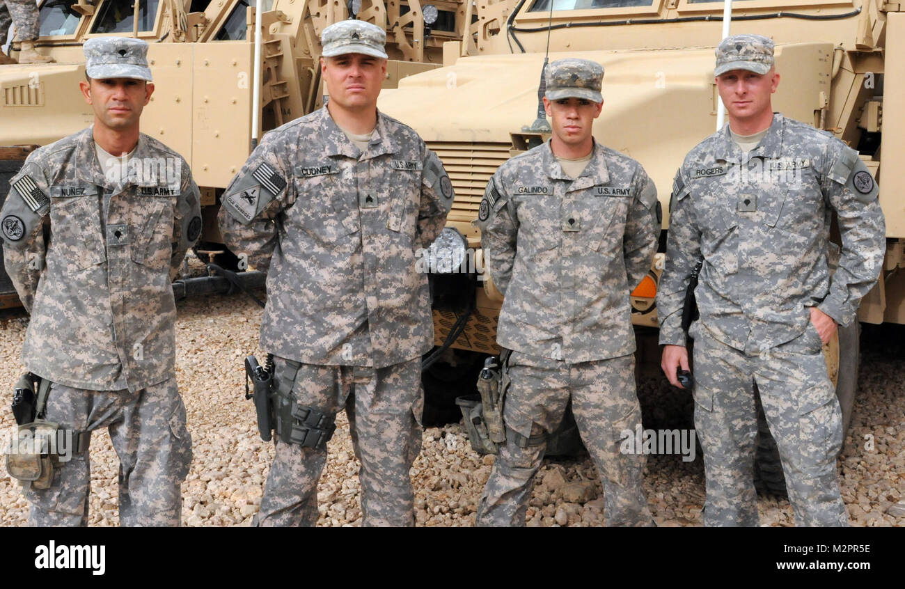 DIWANIYAH, Iraq – Spc. Cesar Nunez from Los Angeles, Sgt. Anthony Cudney from Vallejo, Calif., Spc. Nick Galindo from Apple Valley, Calif., and Spc. Lloyd Rogers from Tuscumbia, Ala., all armored vehicle crewman with Company M, 3rd Squadron, 3rd armored Cavalry Regiment pose in front of their truck on Forward Operating Base Endeavor May 7. The crew conducts daily security missions in the area surrounding FOB Endeavor and the city of Najaf, and supports the Diwaniyah Provincial Reconstruction Team projects. US Army photo by Staff Sgt. Garrett Ralston (110507-A-8856R-003) Vigilant Soldiers by Un Stock Photo