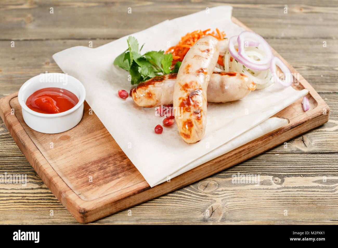 grilled sausages. Serving on a wooden Board on a rustic table. Barbecue