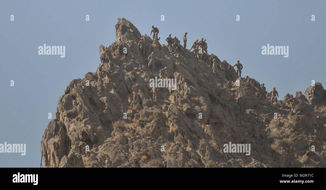 Soldiers from the 1st Stryker Brigade Combat Team, 25th Infantry Division climb to the top of the mountain surrounding Forward Operating Base Masum Ghar for a reenlistment/promotion ceremony on 2 October. U.S. Army Photo by Pfc. Andrew Geisler, 1/25 SBCT Public Affairs 111002-A-9186G-017 by 1 Stryker Brigade Combat Team Arctic Wolves Stock Photo
