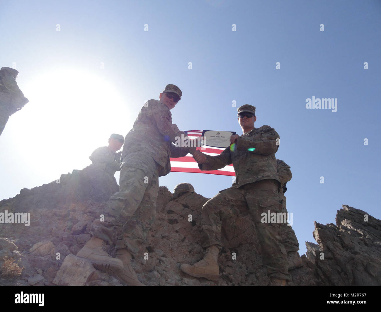 Col. Todd Wood, Commander of the 1st Stryker Brigade Combat Team, 25th Infantry Division, reenlists Cpl. Wiley Pritchett, an infantryman with the 1/25 SBCT Tactical Assault Command, in a ceremony at the top of the mountain above Forward Operating Base Masum Ghar on 2 September. U.S. Army photo by Sgt. 1st Class Melanie Currasco 1/25 SBCT Communications Shop 111002-A-3728C-007 by 1 Stryker Brigade Combat Team Arctic Wolves Stock Photo