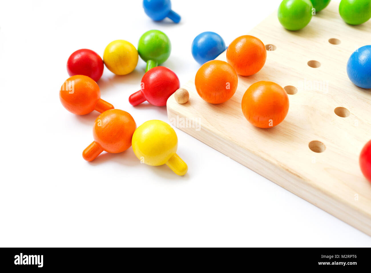 Colored pegs board, wood beads on white background Stock Photo