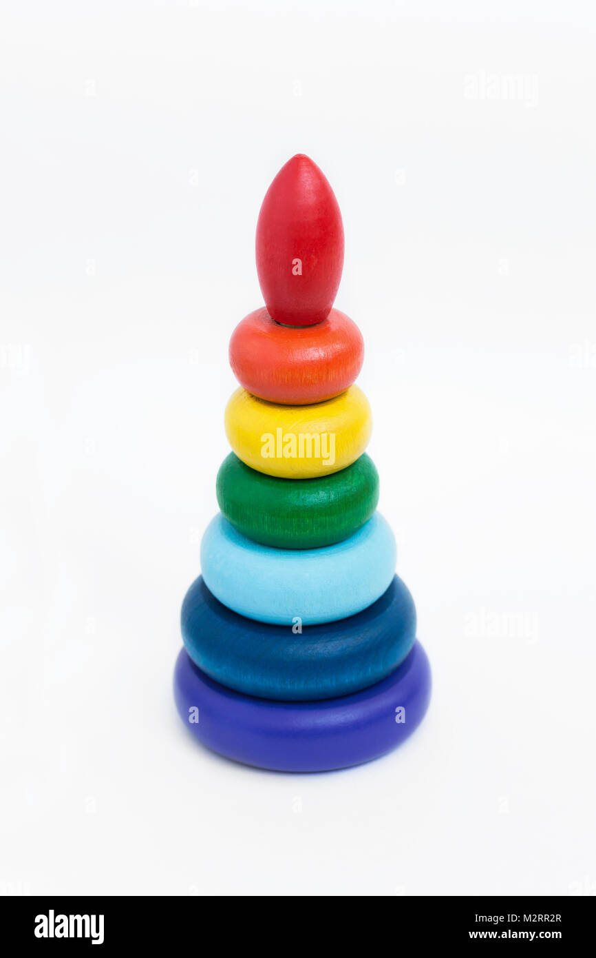 Children's wooden multi-colored pyramid on a white background. A toy ...
