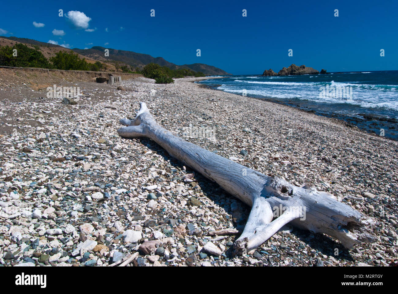 Gravel beach with eroding road due to Hurricane storm near Pilon, south coast of Province Granma, Cuba Stock Photo