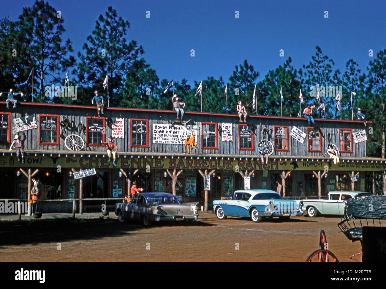 The Cheyenne Barbeque Ranch, an eccentric food restaurant, Florida, c. 1958. The rustic frontage includes mannequins dressed in cowboy clothing, animal horns and hand-wrtten signage with some interesting spelling - eg 'Howdy podner!', 'Come an' git it!' Stock Photo