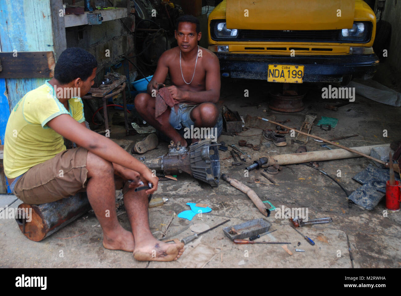 Car mechanic disassembling transmission in shop, Baracoa, Cuba Stock Photo