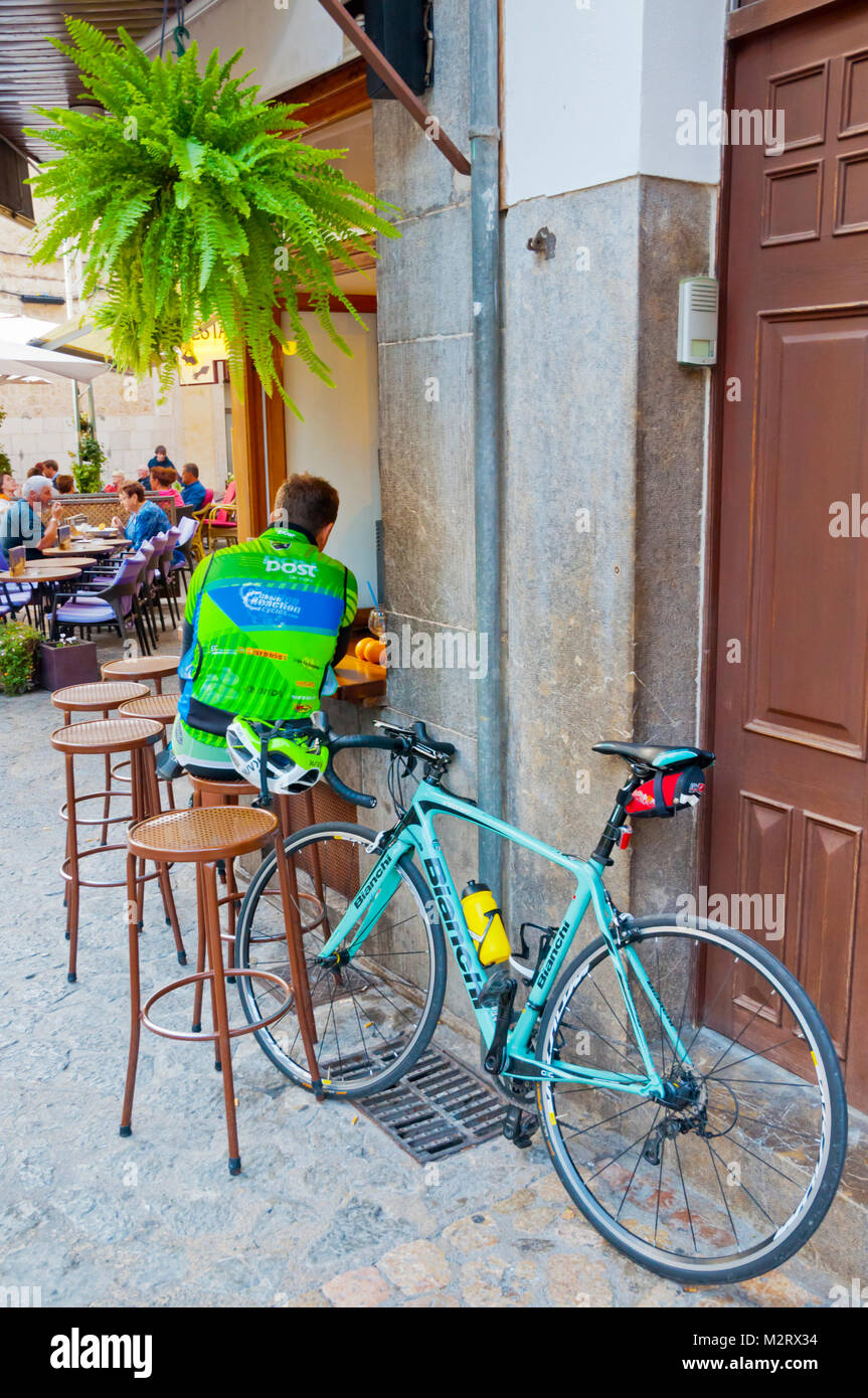 Cyclist taking a break, Placa de sa Constitucio, main square, Soller, Mallorca, Balearic islands, Spain Stock Photo