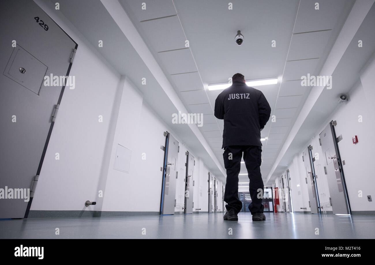 Hamburg, Germany. 08th Feb, 2018. A prison guard standing in the recently renovated B-wing of the Holstenglacis remand centre during a tour for the press in Hamburg, Germany, 08 February 2018. There are 99 cells waiting for inhabitants in a completely modernised wing of Hamburg's Holstenglacis remand centre. The institution, after almost three years of renovation work, now counts with a total of 484 places for prisoners in remand. Credit: Christian Charisius/dpa/Alamy Live News Stock Photo