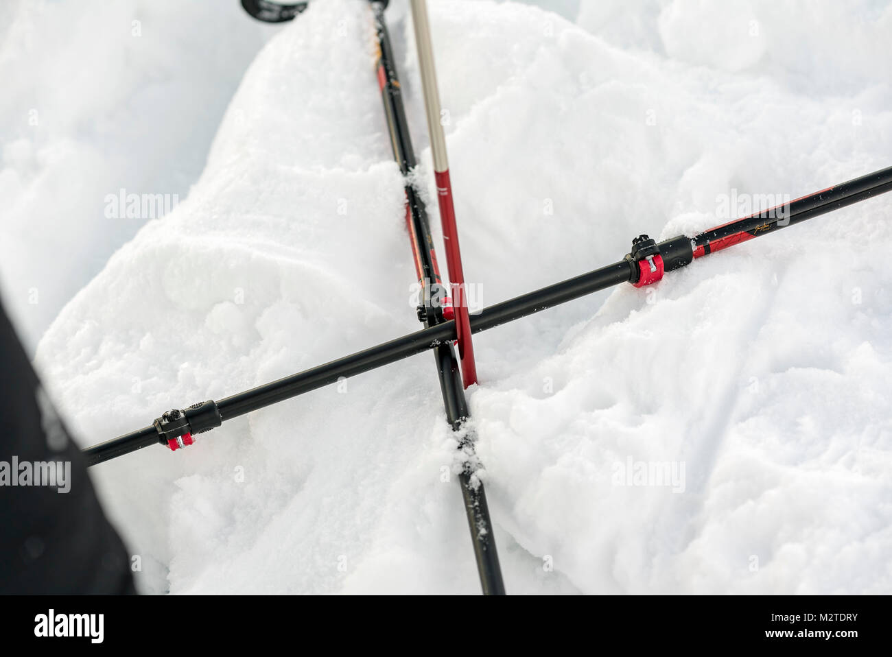 Mountain Leader explains how to avoid avalanches and how to use winter equipment to a group of people in the snowy mountains Stock Photo