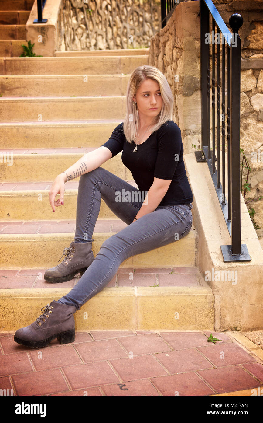 Beautiful blonde girl wearing tight jeans and a black t-shirt outdoors  Stock Photo - Alamy