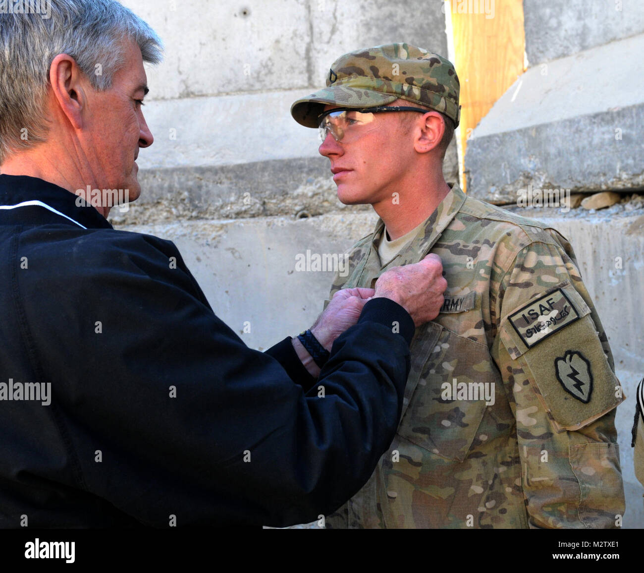 Secretary of the Army John M. McHugh presents the Purple Heart to Pfc. Steven Gagnon, an infantryman with 1st Battalion, 5th Infantry Regiment, 1st Stryker Brigade Combat Team, 25th Infantry Division, originally from Porter, Maine, in a ceremony at Forward Operating Base Masum Ghar on Dec. 14. US Army photo by Sgt. Michael Blalack, 1/25 SBCT Public Affairs 111214-A-AX238-007 by 1 Stryker Brigade Combat Team Arctic Wolves Stock Photo