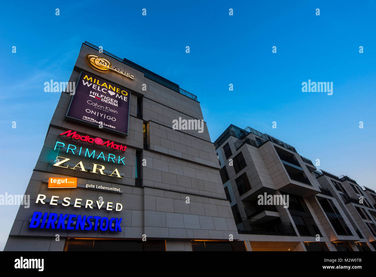 advertisement for brands on the shopping centre MILANEO, blue hour,  architects RKW Rhode Kellermann Wawrowsky, in new part of town  Europaviertel, Mailänder Platz (square), Stuttgart, Baden-Wurttemberg,  Germany Stock Photo - Alamy