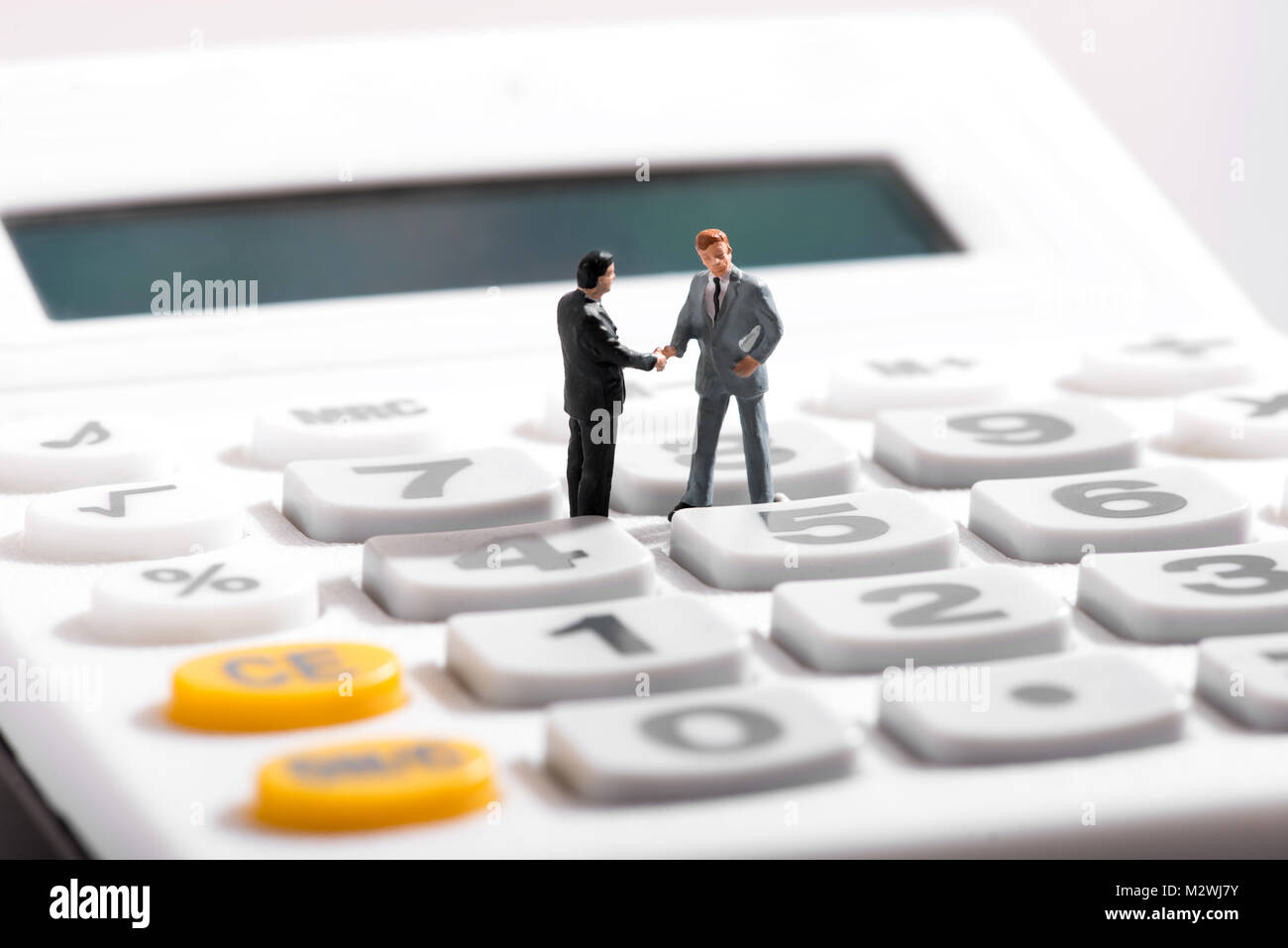 Business concept with two figurines of businessmen standing on calculator Stock Photo
