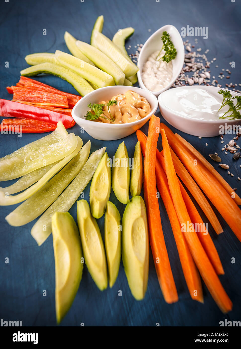 Assorted fresh vegetables with dip on blue background Stock Photo Alamy