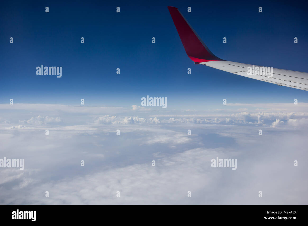 Wing of an airplane flying above the clouds Stock Photo - Alamy