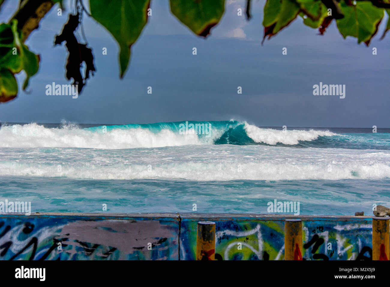 Welle rollt auf die Schutzmauer in Malé, Malediven, zu. Die davor liegende Straße am Surfers Point wird oft überschwemmt. Stock Photo