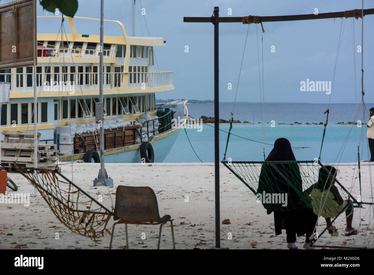 Velidhoo, Einheimischeninsel auf den Malediven, Mutter und Kind warten auf Abfahrt der Fähre Stock Photo