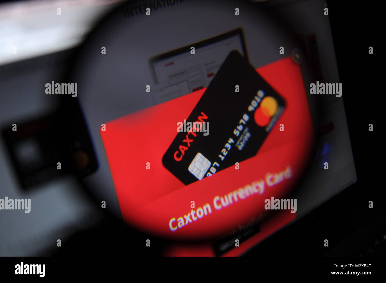 The Caxton FX website seen through a magnifying glass Stock Photo