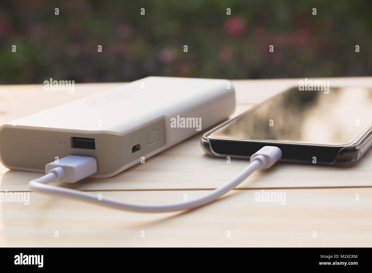 Mobile smart phones charging with power bank on desk Stock Photo Alamy